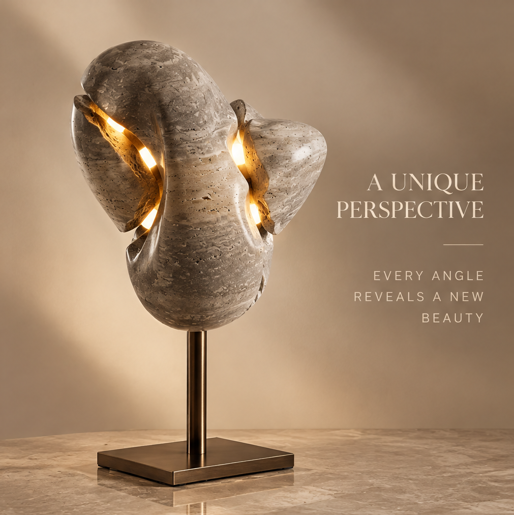 VITALUXO organic stone sculpture lamp illuminated from within showing warm LED glow through stone gaps on brushed metal stand — A Unique Perspective, Every Angle Reveals a New Beauty